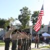 Boy Scouts saluting the American flag in front of First Avenue School
