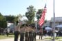 Boy Scouts saluting the American flag in front of First Avenue School