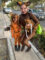 A woman holding her dog and her child dressed in cat customs