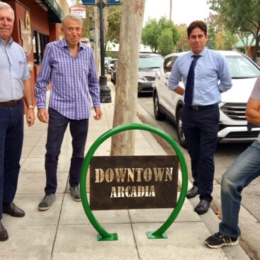 a group of men in Downtown Arcadia by a bike rack