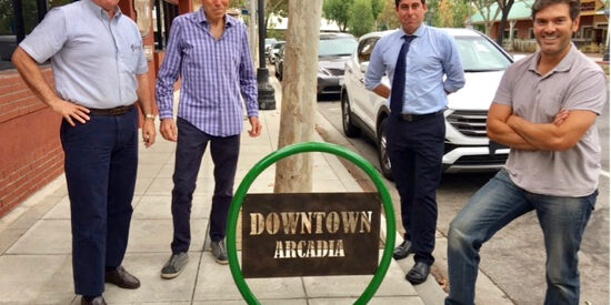 a group of men in Downtown Arcadia by a bike rack