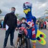 Young boy with his father winning a bike posing with Purdy mascot
