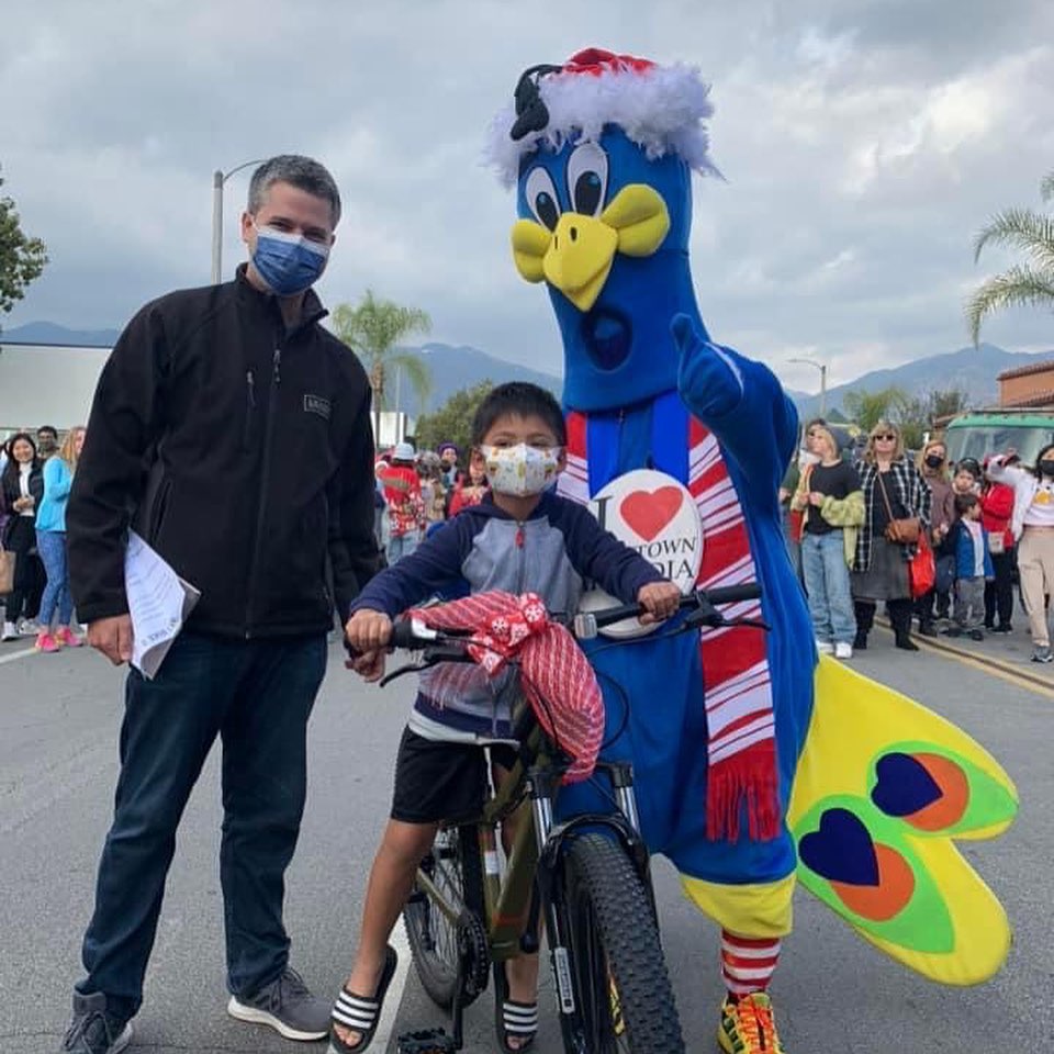 Young boy with his father winning a bike posing with Purdy mascot