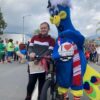 Young girl winning a bike posing with Purdy mascot